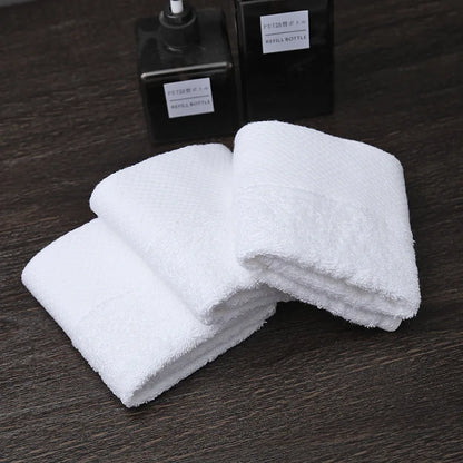 Petites serviettes visage blanche pliées et empilées sur un meuble de salle de bain