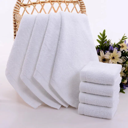 Petites serviettes visage blanche pendue sur un meuble de salle de bain
