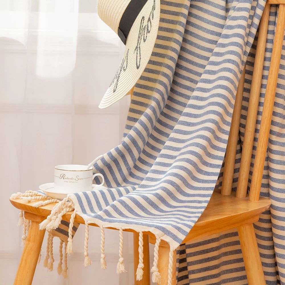 Serviette de plage à petite rayures bleue posée sur une chaise